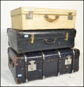 A stack of mid century vintage suitcases to include a black faux leather example with another faux