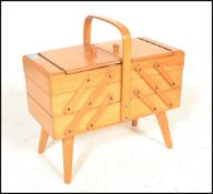 A retro 20th Century beech cantilever metamorphic work / sewing box, carry handle over sectional
