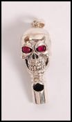 A stamped 925 silver whistle in the form of a skull set with ruby eyes. Weight 15.7g.