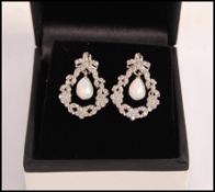 A pair of stamped 925 silver drop earrings set with pear shaped opalite panels, surrounded with