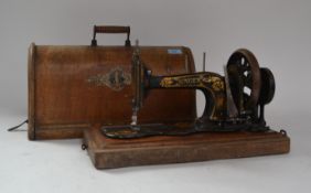 An early 20th century dome top oak cased Singer sewing machine. The case complete with key and