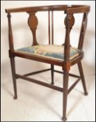 An Edwardian mahogany inlaid corner chair. Raised on turned legs with pad seat united by stretchers.