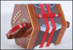 The Gremlin- A 20th century twenty one button concertina / squeeze music box, having pierced