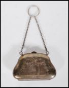 A silver hallmarked coin purse being engraved with bows and floral garlands with chain to the top,