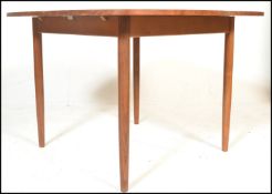 A retro teak wood 20th Century extendable dining table raised on tapering shaped supports together