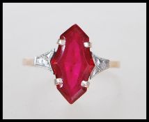 A 9ct gold ring having prong set synthetic fancy cut ruby with white gold shoulders on a lozenge