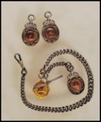 A silver hallmarked fob watch chain having three oval medals with unengraved gold plated central