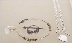 A collection of silver stamped 925 jewellery to include bangle, dress ring set with a cabochon white