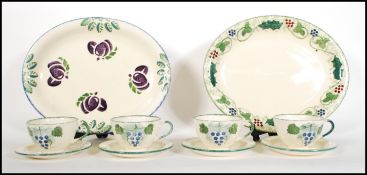 A small group of Poole Pottery ceramics in the Vineyard pattern to include four cups and saucers and