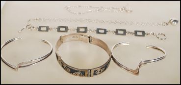 A group of silver bracelets to include a Mexican panel bracelet, two ripple design brangles, a chain