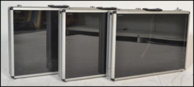 A group of three 20th century aluminium flight / travel cases having toughened glass lids for