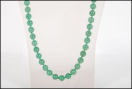 A vintage Chinese green jade or Peking glass prayer bead necklace having a set of round beads. Total