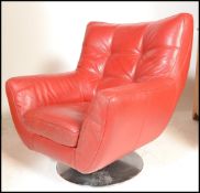 A 20th Century red leather swivel easy lounge armchair, spoon back with scroll arms raised on a