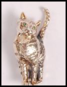A stamped 925 silver brooch in the form of a cat set with emerald eyes. Weight 7.7g. measures 3.