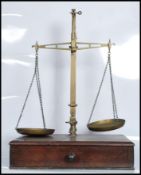 A set of 19th Century Victorian brass balance scales by W.T. Avery, the scales set to a mahogany