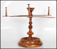 An early 20th Century Olive wood tabletop Lignum Vitae style metamorphic wool winder, having three