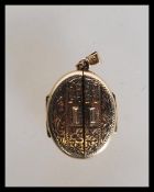 A 9ct gold hallmarked unusual double door locket being chase decorated with twin doors and bale