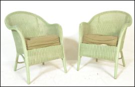A matching pair of 20th Century wicker Lloyd Loom bedroom armchairs finished in light green having