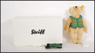 A boxed Steiff mohair teddy bear 004230 'Flying Scotsman' wearing a green scottish waistcoat, having