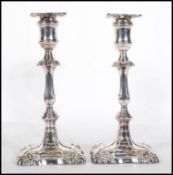 A pair of 20th Century Martin Hall & co silver plated candlesticks of rococo form being cast in
