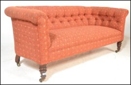 A Victorian 19th century Chesterfield sofa settee being raised on oak turned legs with brass ceramic