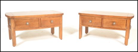 A pair of contemporary oak coffee tables of rectangular form with curved end table tops having