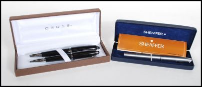 A boxed pen set by Cross consisting of a ballpoint pen and fountain pen finished in black.