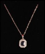 A stamped 18ct white gold necklace having a fine link chain with a sapphire pendant set diamond