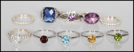 A good collection of ten silver rings marked 925 having blue, yellow, green, red stones in cluster