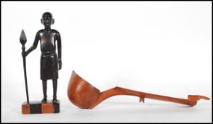 A vintage carved ebony African tribal figure of a tribal warrior with spear in hand, set to a square