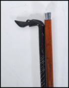 Two 20th Century walking stick canes of tapering form. One having a silver knob handle on a