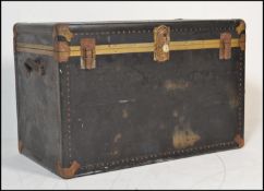 A large vintage travel trunk chest having metal brass style banding with leather carrying handles to