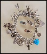 A silver hallmarked charm bracelet having silver heart clasp with an assortment of silver charms