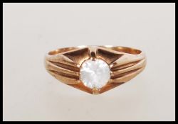 A hallmarked 9ct gold ring claw set with a round cut white stone with reeded shoulders. Hallmarked
