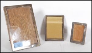 A group of three silver hallmarked easel back desk top picture frames, the largest with Birmingham