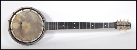 An early 20th Century eight string banjo having a raw hide drum within a wooden case having inlaid