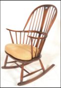 An Ercol beech and elm 20th century large comb back Windsor pattern rocking chair / armchair. Raised