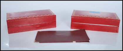 Two vintage Cartier style red leatherette glasses boxes having gilt detailing along with a red
