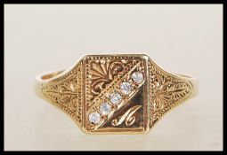 An unmarked 9ct gold signet ring having a square head having a row of white stones engraved with the