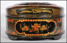 An early Chinese lacquer box of round form having a black ground with having painted cartouche