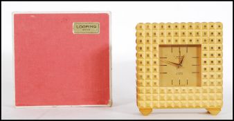 A mid century Swiss gilt metal mantel clock by Looping. The swiss movement set within a stunning