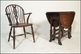 A 19th century beech and elm Windsor chair / armchair raised on turned legs with saddle seat and