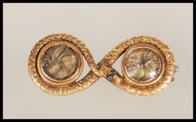 A 14ct gold textured snake mourning brooch with inset plaited hair under two glass windows,