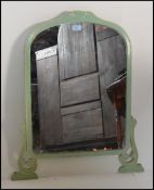 A 1920's Art Deco mirror finished in green having shaped dome top raised on music note feet.