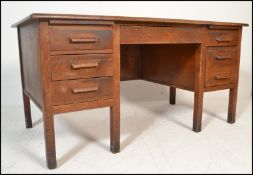 A mid 20th Century Air Ministry style oak twin pedestal desk raised on squared legs with a series of