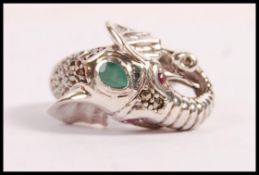 A stamped 925 silver ring in the form of an elephant set with a pear shaped emerald to the head,