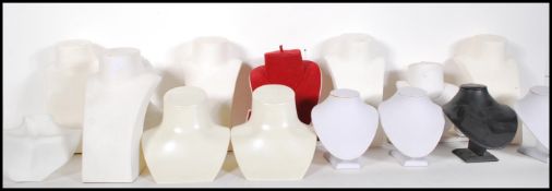 A collection of shop display jewelry necklace stands of various size, some having coloured velvet