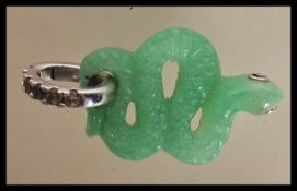 A carved jade pendant in the form of a snake having ruby and silver eyes on a silver 925 pendant