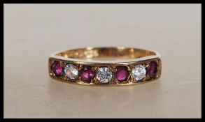 A hallmarked 9ct gold ring set with round cut alternate white and red stones. Hallmarked Edinburgh