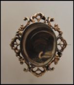 A 19th Century Victorian gold plated mourning brooch having an oval window to the front set with